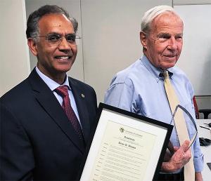 Former Council Chair Ravinder Singh presents President Bruce Benson with the Leadership in Public Higher Education Award.