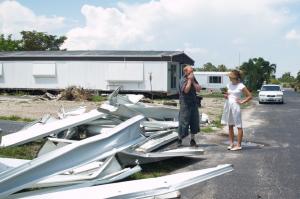 Esther and a park resident watched as movers tore apart the additions he made to his mobile home so it could be readied for transport away from the park, which was about to close.