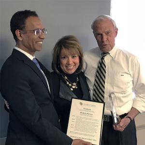 Michelle Martinez receives her award from Faculty Council Chair Ravinder Singh and CU President Bruce Benson.