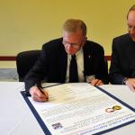 Theodore Drier (left), senior director, intelligence programs and national security solutions, Dyncorp International, and Martin Wood, senior vice chancellor, University Advancement, sign a statement of support with the Army Reserve Feb. 10.