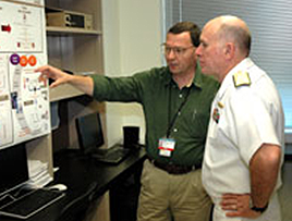 U.S. Navy Surgeon General Matthew Nathan, right, hears about bladder cancer research from Dan Theodorescu, M.D., director of the CU Cancer Center, during a tour of the Anschutz Medical Campus.