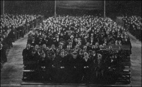 A student assembly in the as-yet finished Macky Auditorium. The building took years to complete due to lawsuits by the Macky family and the state.