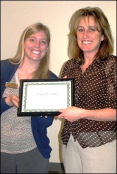 Elyse Dunckley, right, receives her award from Shannon Cable, general professional in the Office of Financial Aid and Student Employment and co-president of the Employee of the Quarter committee.
